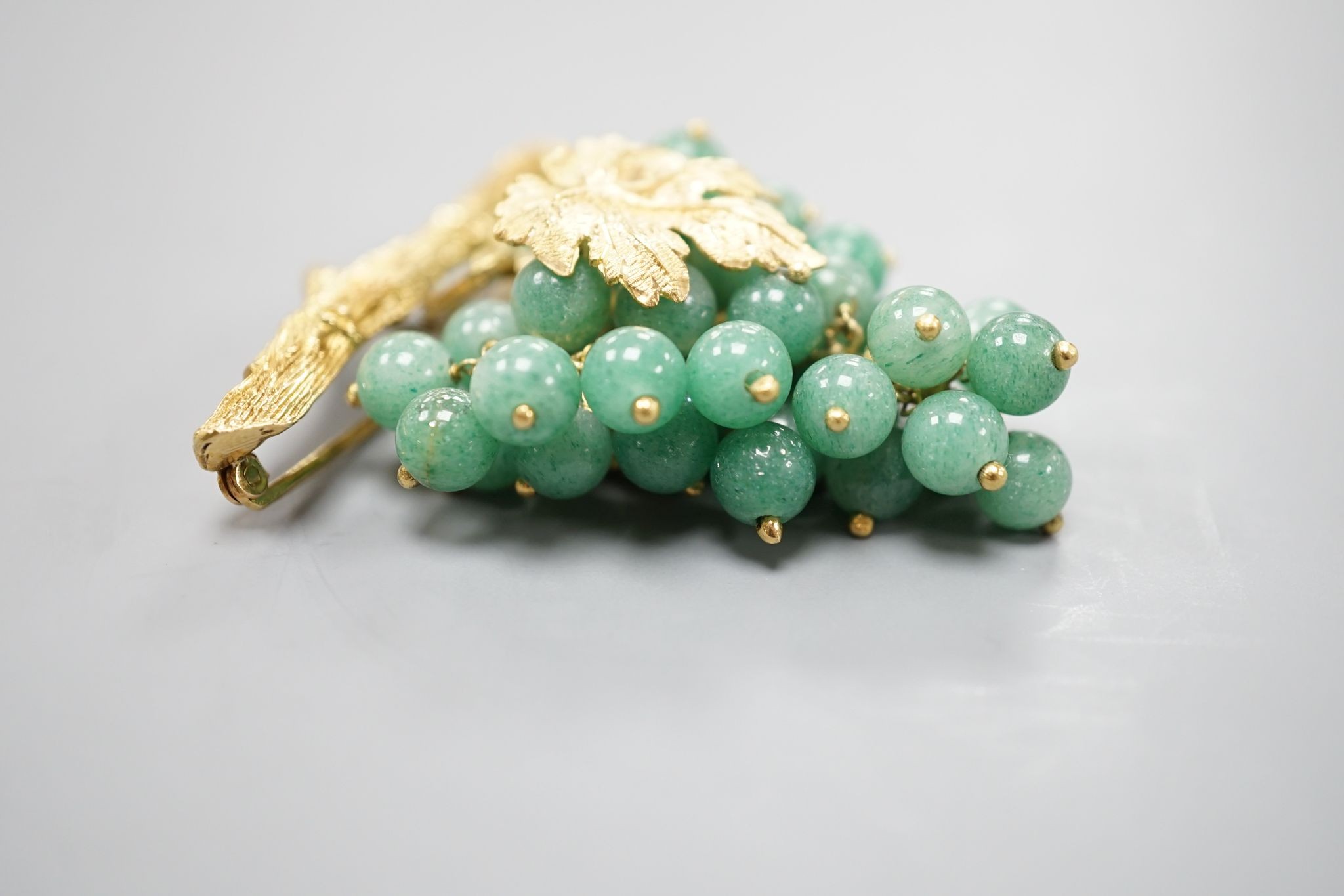 A 20th century continental 18k yellow metal and adventurine quartz bead set brooch, modelled as a bunch of grapes hanging from a branch, 59mm, gross weight 30.4 grams.